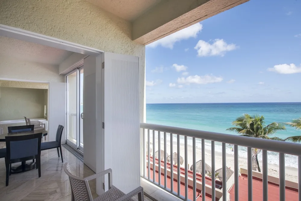 Balcony with chairs overlooking the beach and ocean at Club Regina Cancun.