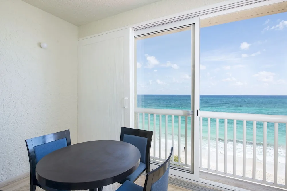 Ocean-view dining table by sliding balcony doors at Club Regina Cancun.