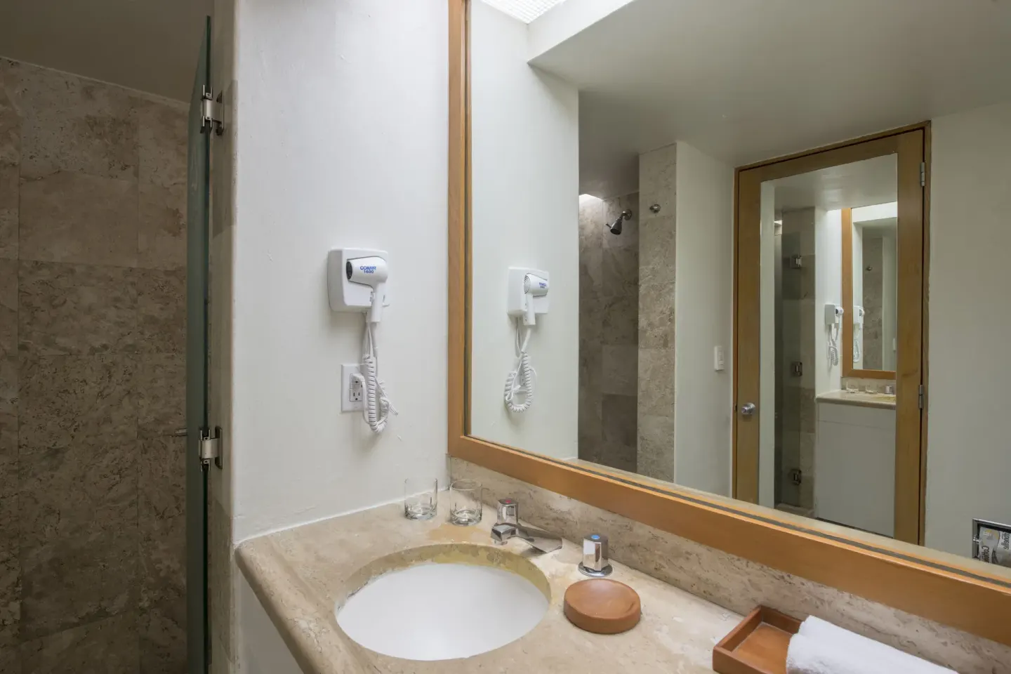 Classic Room bathroom vanity and glass shower at Club Regina Cancun.