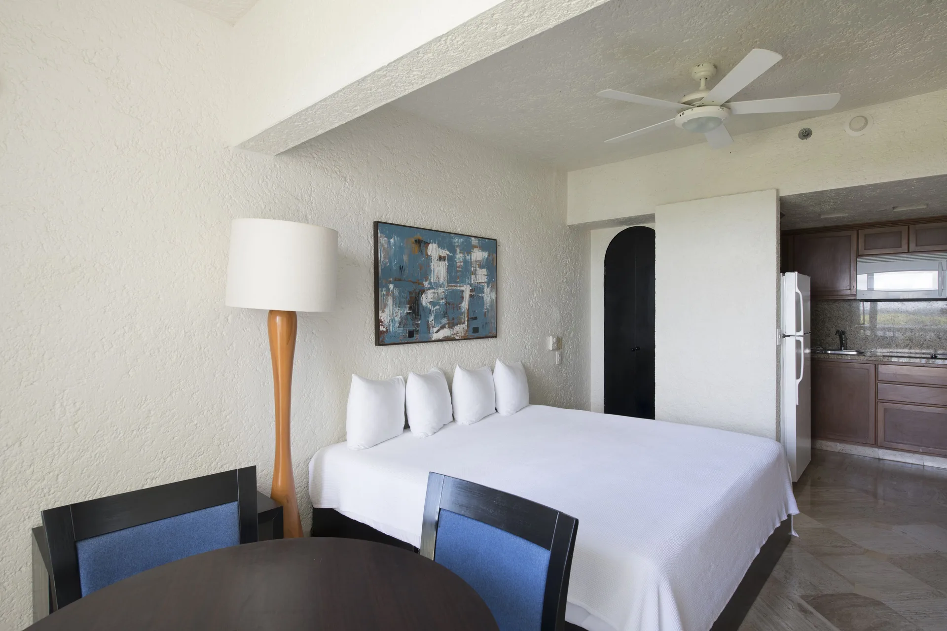 Classic Room with king bed, dining table and kitchenette at Club Regina Cancun.