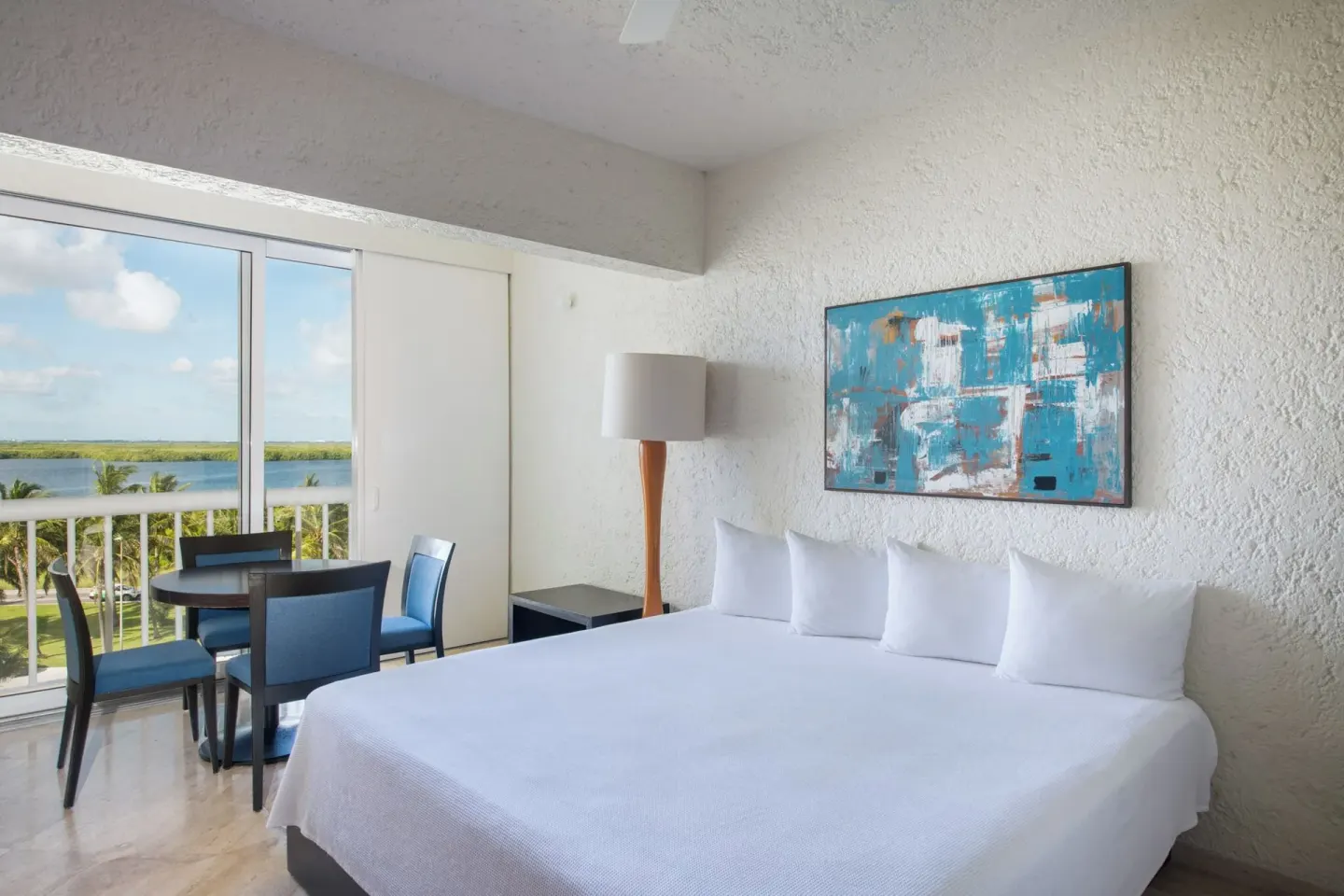 Classic Studio king bed with dining table by the balcony at Club Regina Cancun.