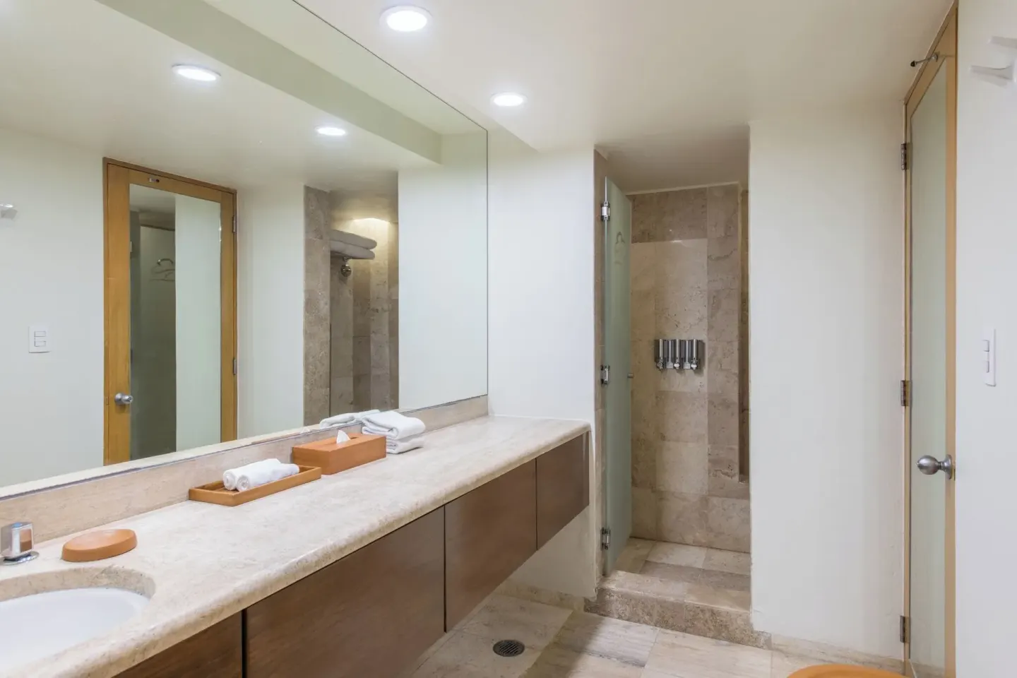 Deluxe suite bathroom with long vanity and walk-in shower at Club Regina Cancun.