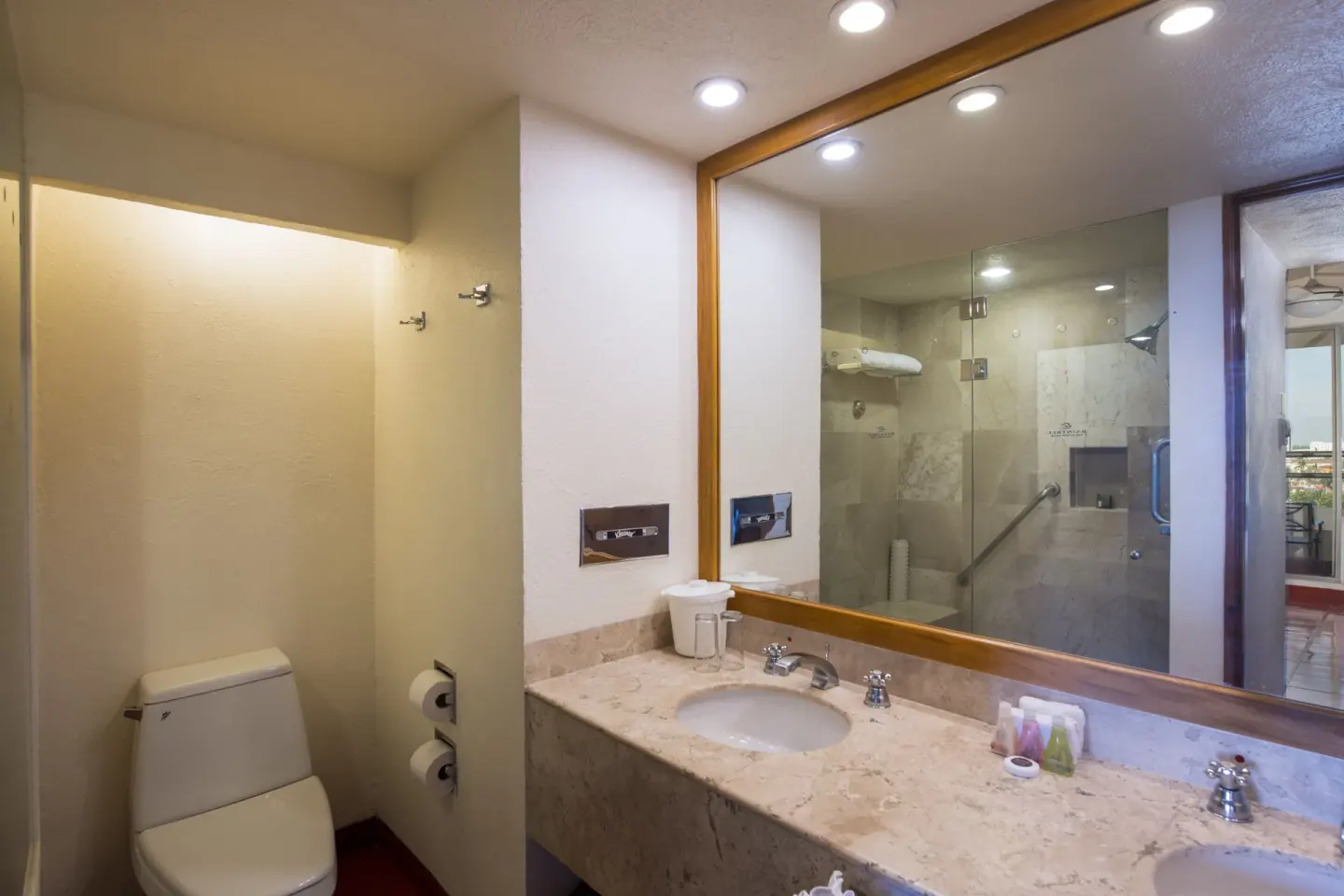 Double-sink bathroom with glass shower at Club Regina Puerto Vallarta.