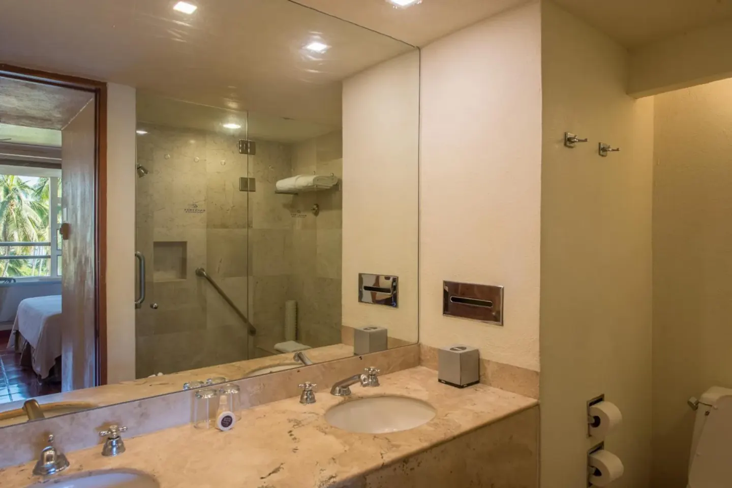 Guest bathroom with marble vanity and glass shower at Club Regina Puerto Vallarta.