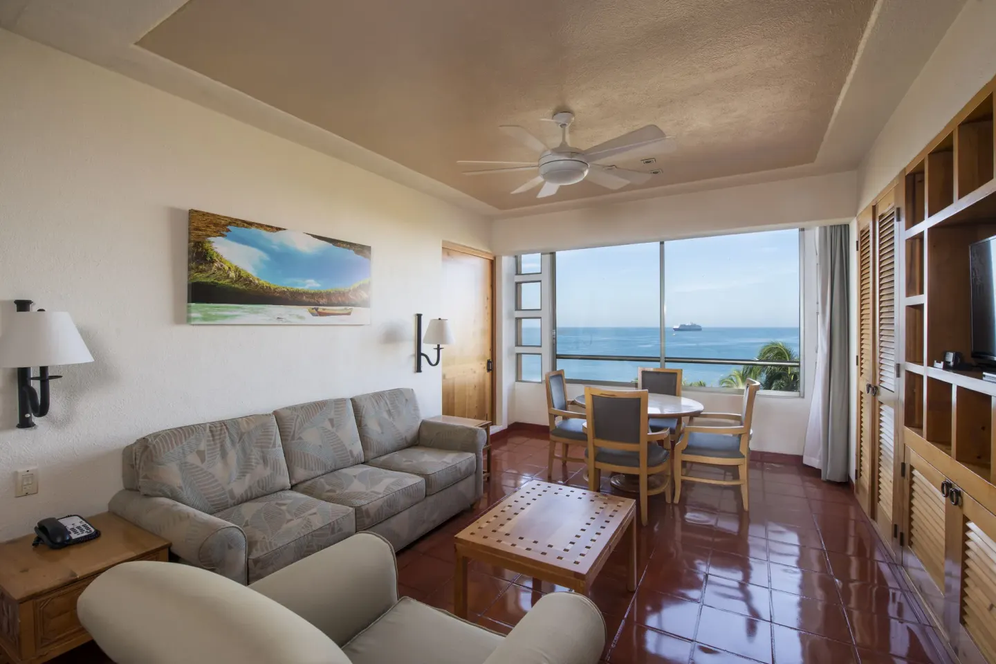Ocean-view living area with sofa and dining table at Club Regina Puerto Vallarta.