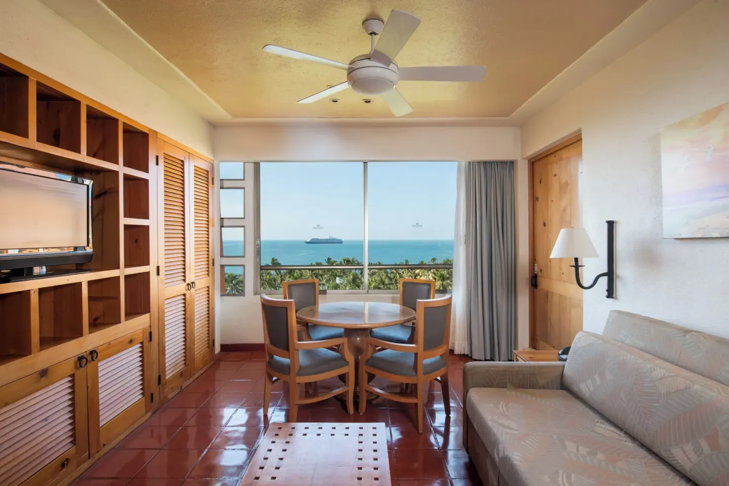 Ocean-view living room with sofa and dining table at Club Regina Puerto Vallarta.