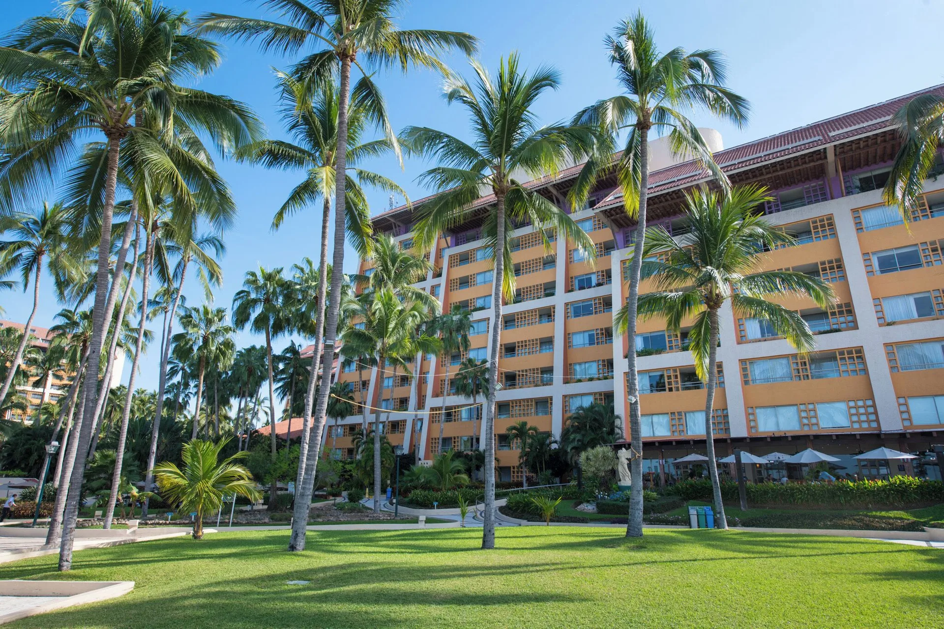 Palm lawn and resort building exterior at Club Regina Puerto Vallarta.