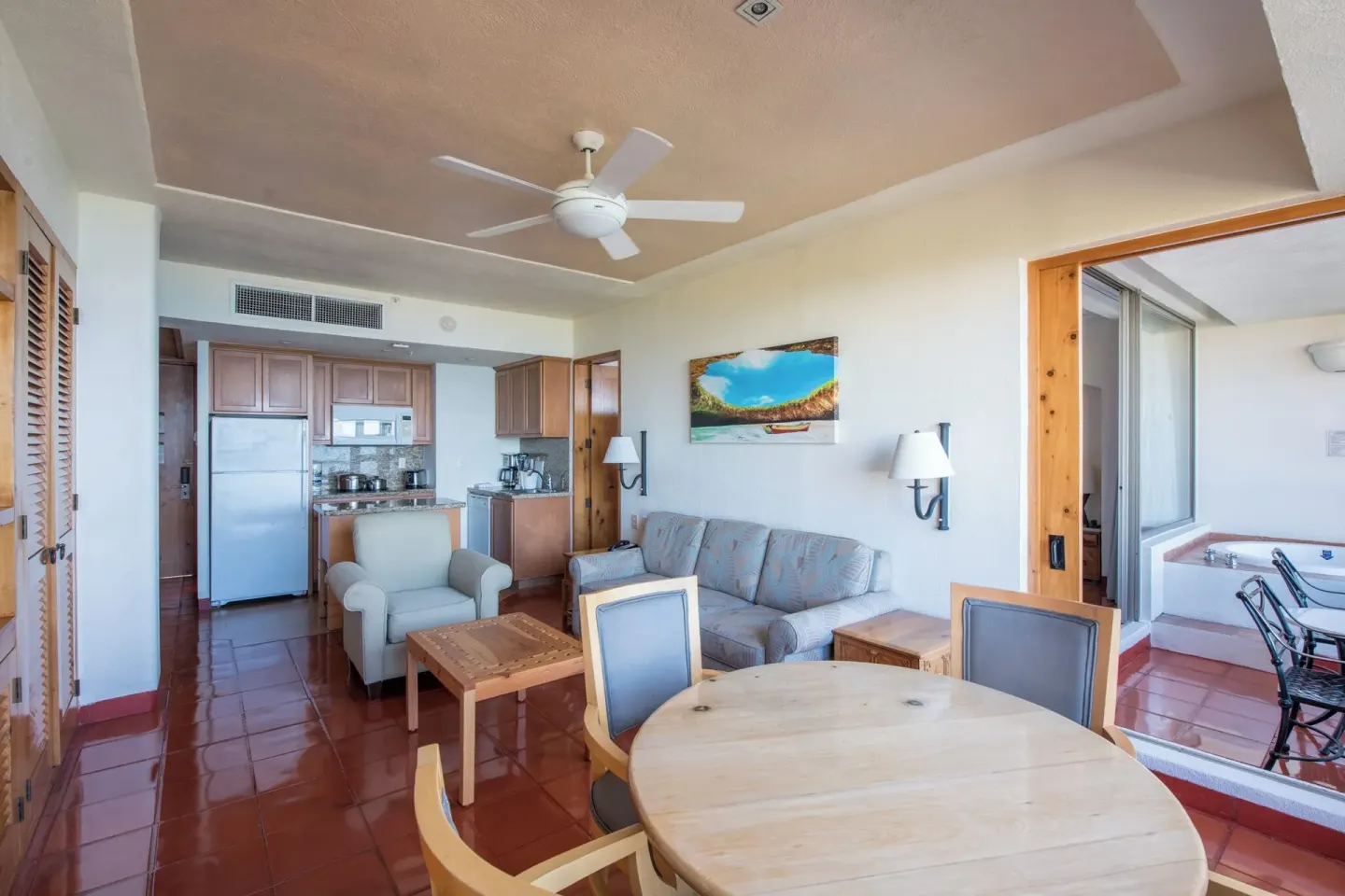 Suite living room with dining table, kitchenette, and balcony access at Club Regina Puerto Vallarta.