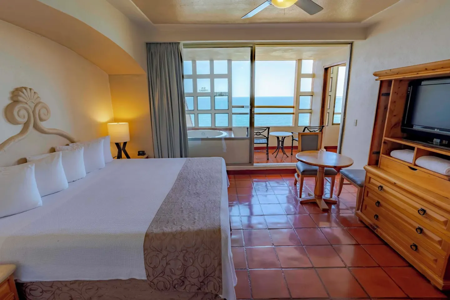 Deluxe suite king bedroom with ocean-view balcony at Club Regina Puerto Vallarta.
