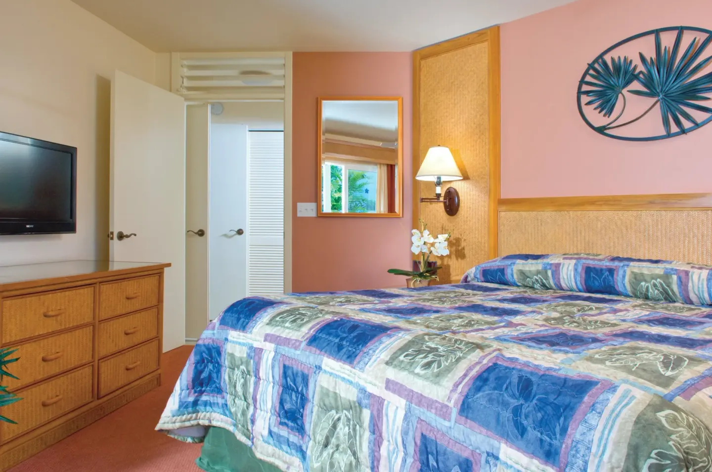 Bedroom with a patterned king bed and dresser at Club Wyndham Bali Hai Villas.