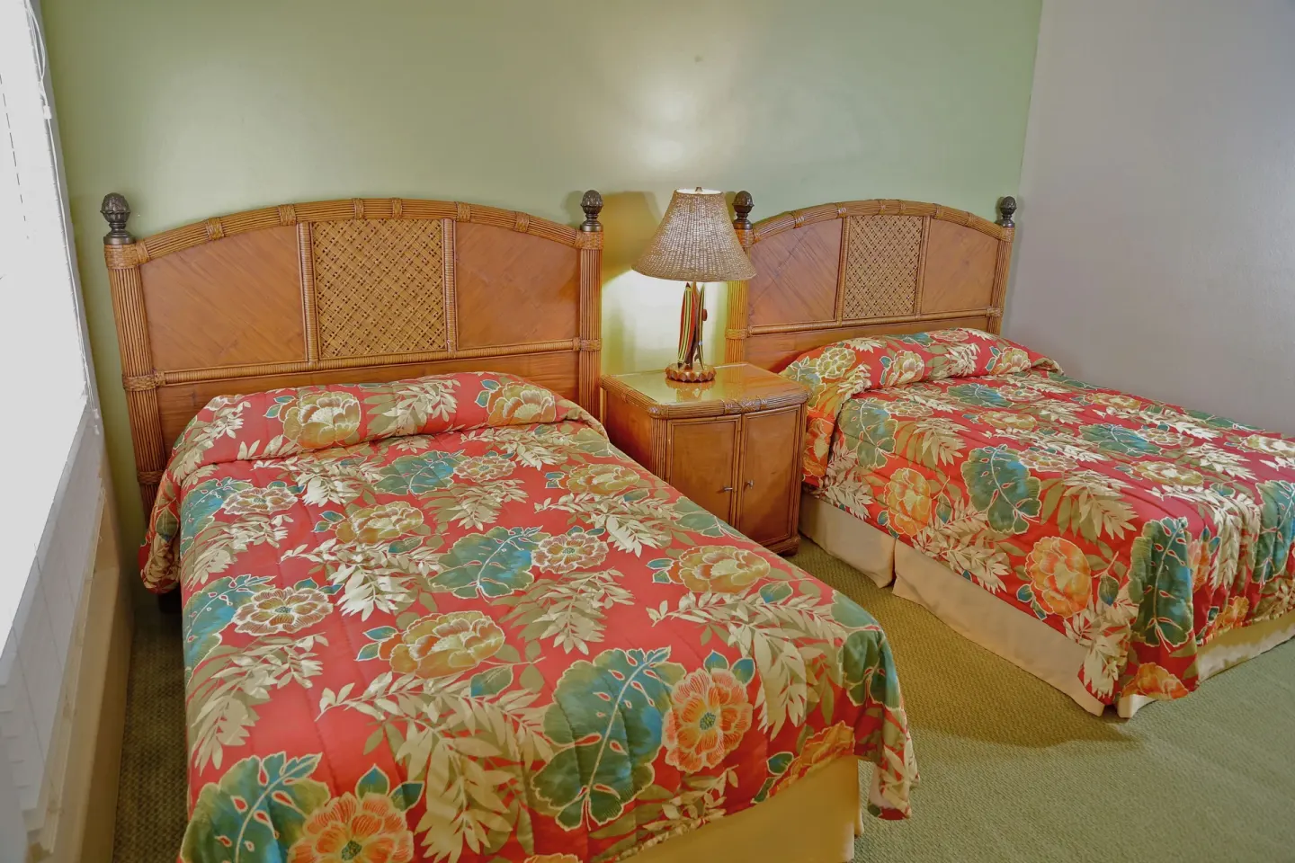 Bedroom with two beds, floral bedspreads, and a shared nightstand at Club Wyndham Bali Hai Villas.