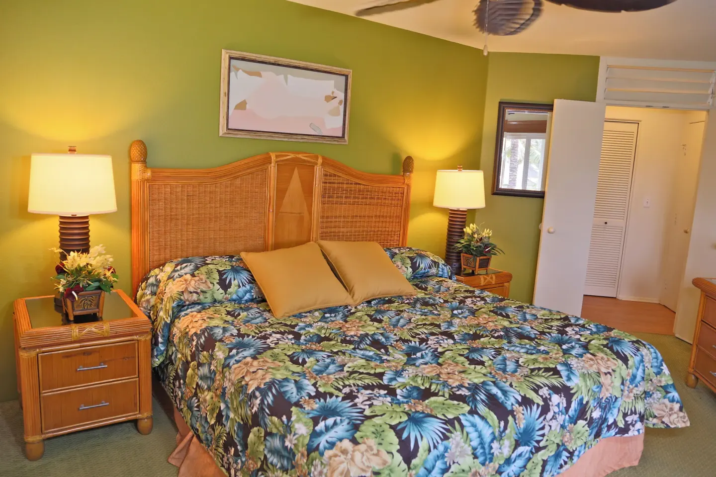 Guest bedroom with a wicker headboard and green accent wall at Club Wyndham Bali Hai Villas.