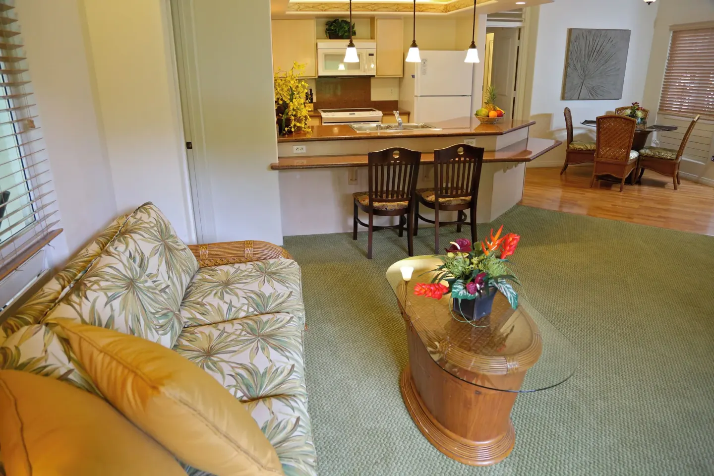 Living room with sofa, coffee table, kitchen counter, and dining area at Club Wyndham Bali Hai Villas.