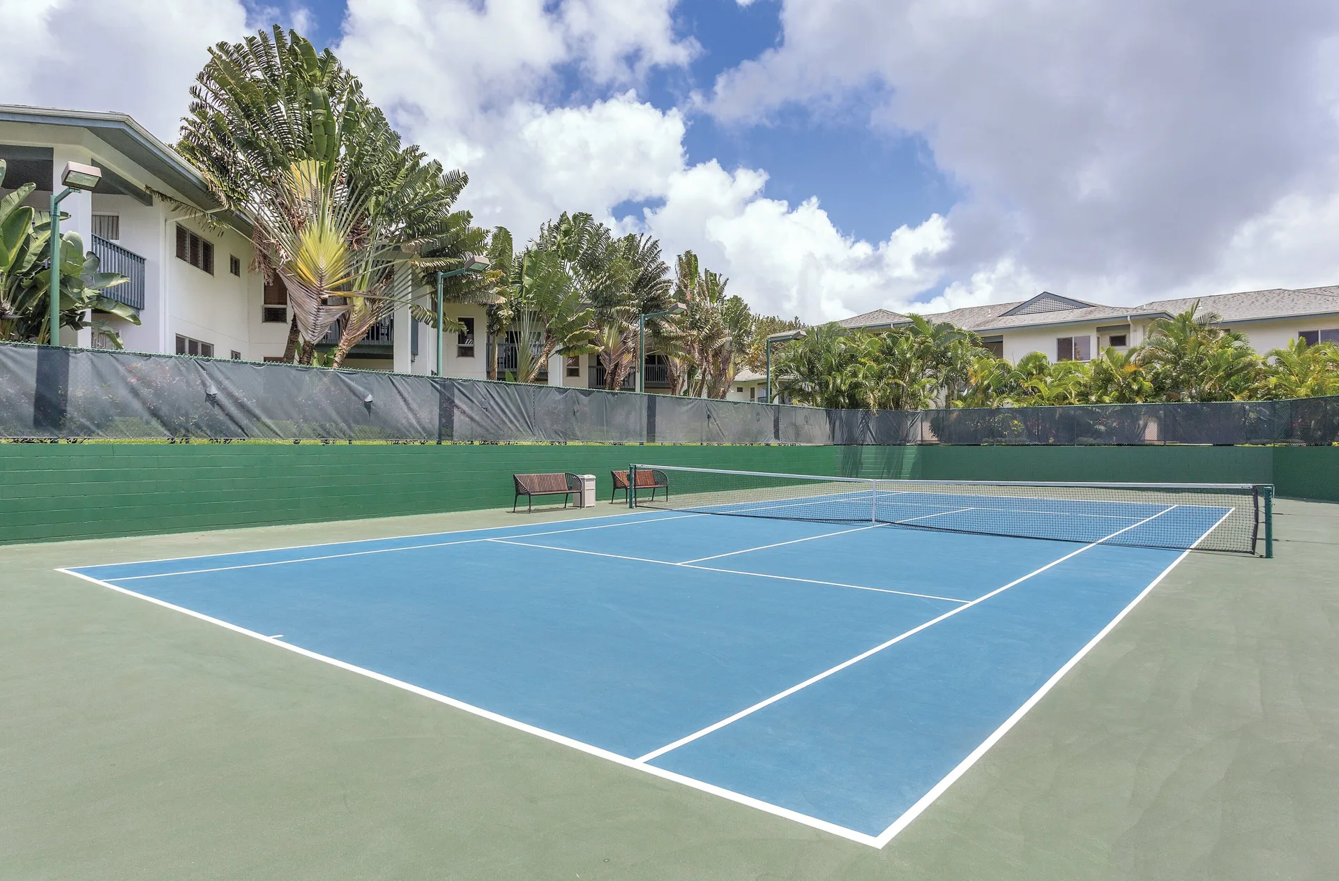 Tennis court with resort buildings and palms at Club Wyndham Bali Hai Villas.
