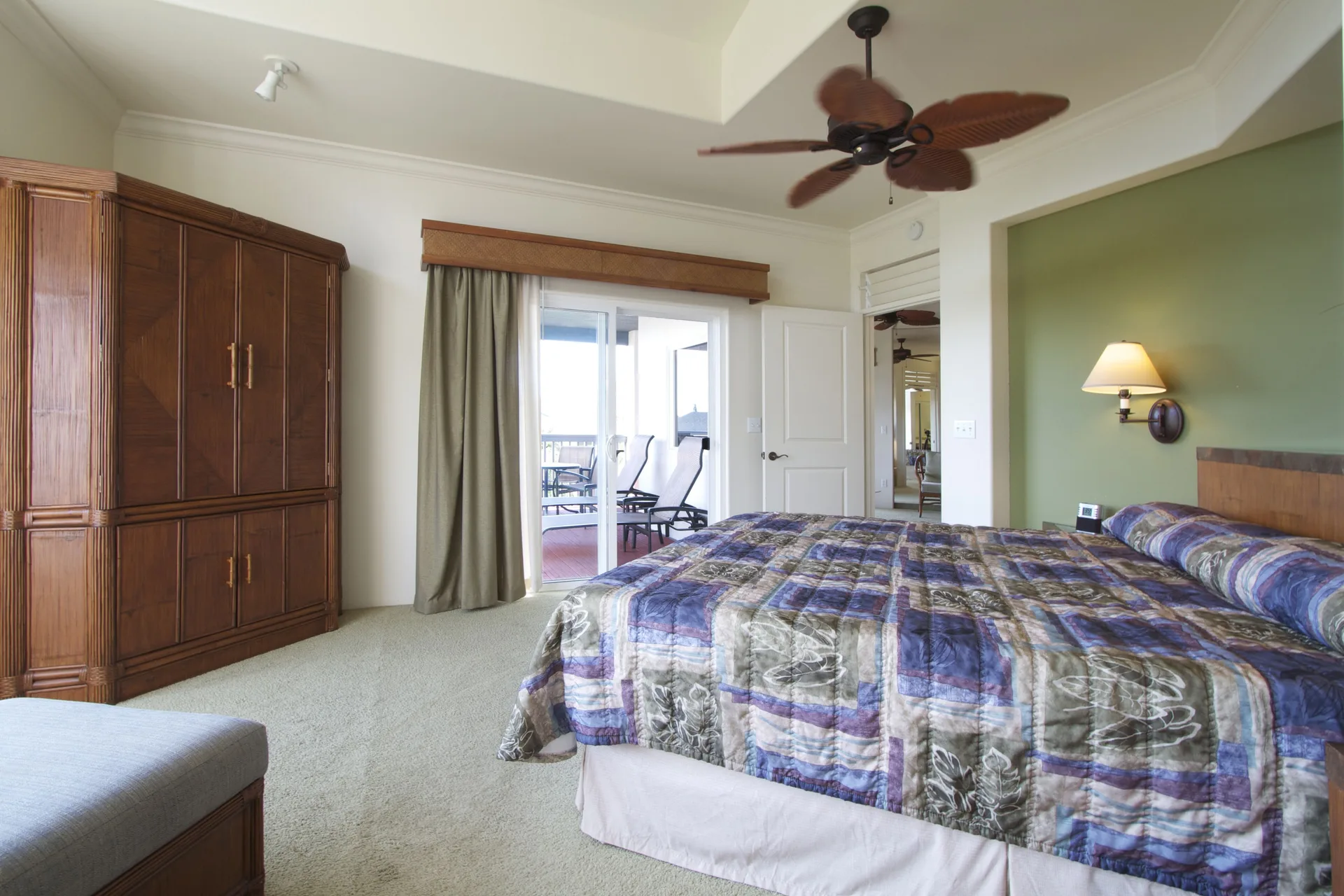 Two-bedroom suite bedroom with king bed and lanai seating at Club Wyndham Bali Hai Villas.