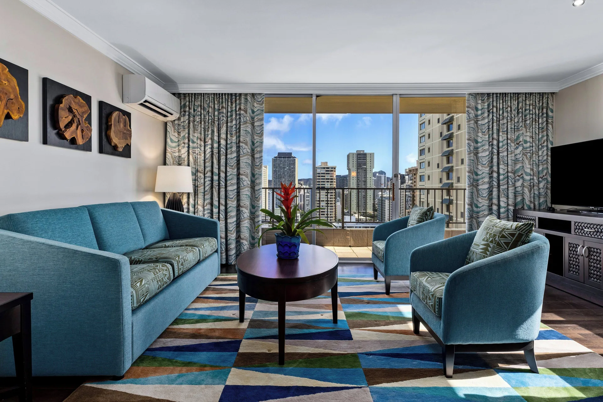 Living area with blue seating and balcony at Club Wyndham Royal Garden at Waikiki.