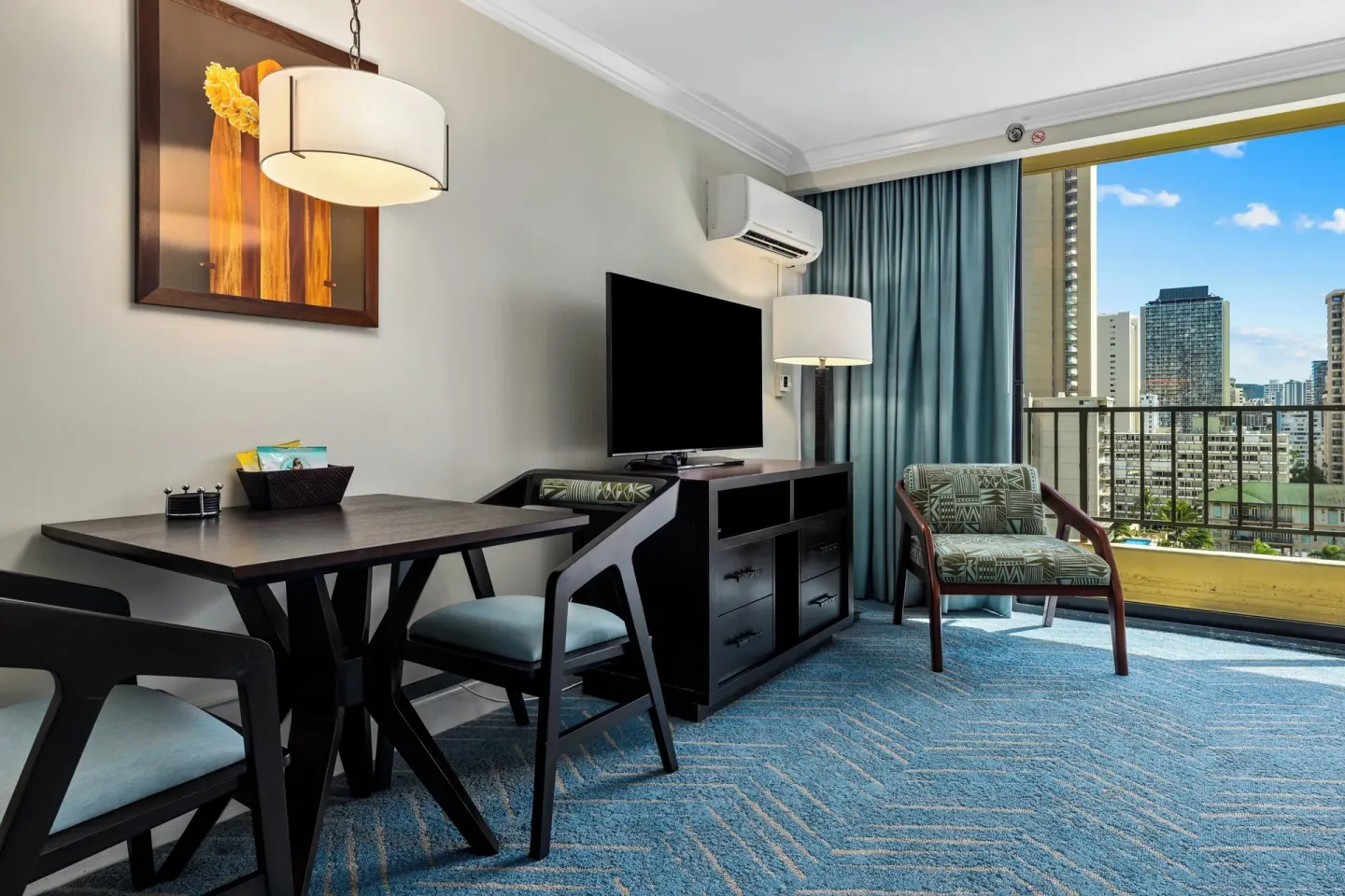 Guest room sitting area with balcony and city view at Club Wyndham Royal Garden at Waikiki.