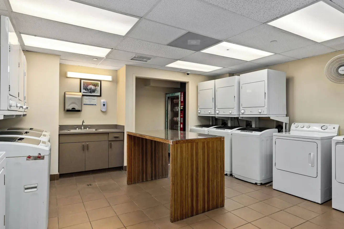 Laundry room with washers, dryers, sink, and folding table at Club Wyndham Royal Garden at Waikiki.