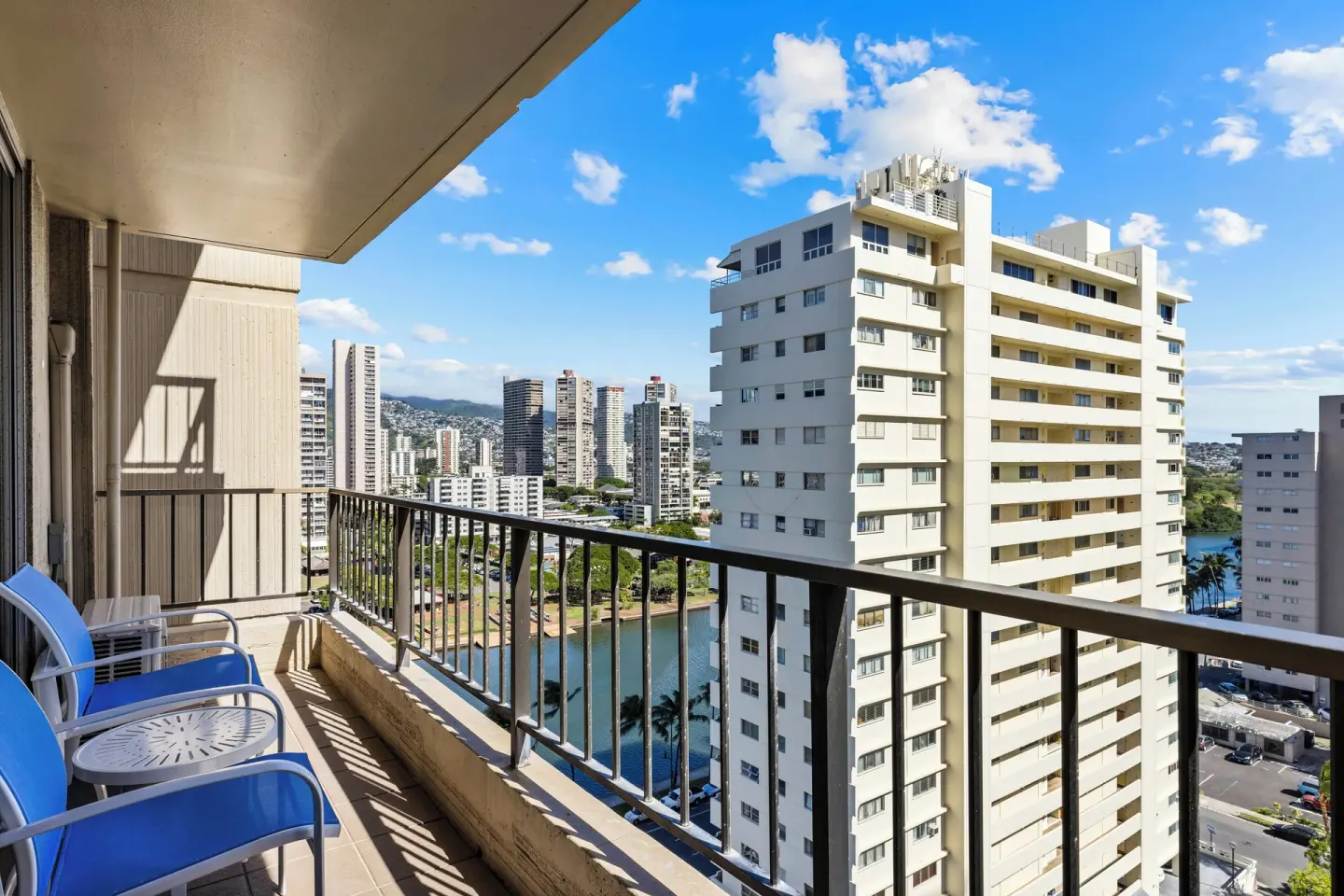 Standard Studio balcony with blue chairs and high-rise city views at Club Wyndham Royal Garden at Waikiki.