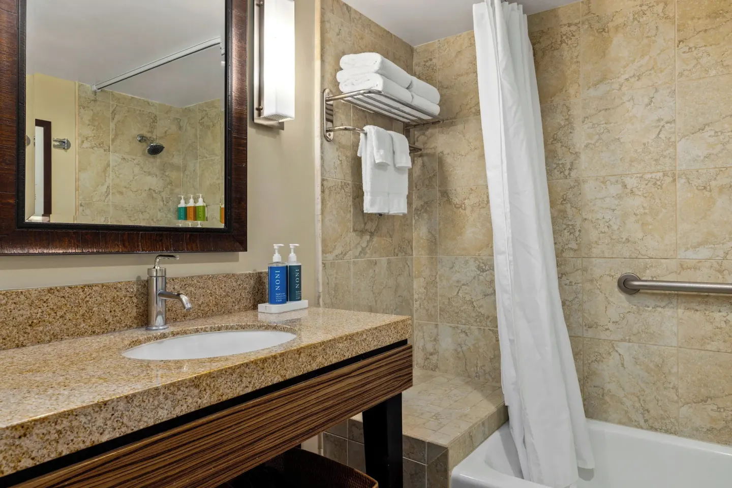 Standard Studio bathroom with vanity, tub, shower curtain, and towels at Club Wyndham Royal Garden at Waikiki.