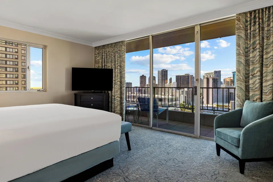 Standard Studio with bed, TV, chair, and balcony at Club Wyndham Royal Garden at Waikiki.