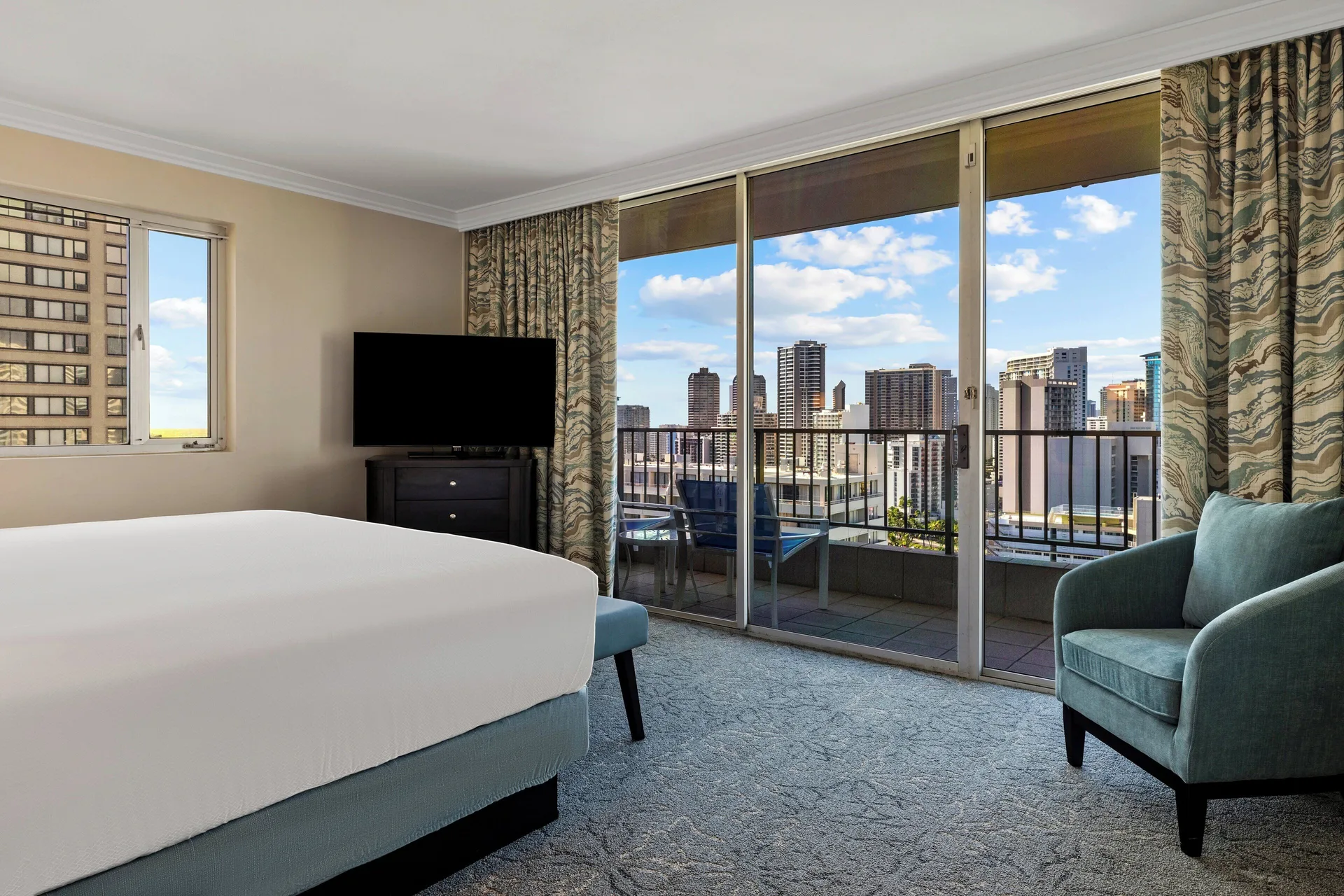 Standard Studio with bed, TV, chair, and balcony at Club Wyndham Royal Garden at Waikiki.