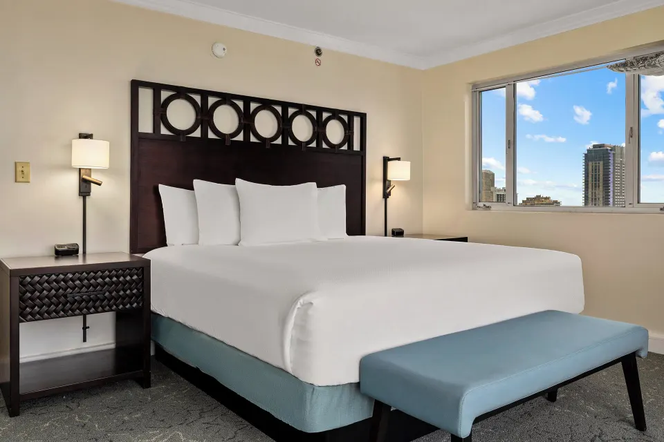 Standard Studio king bed with nightstands and a city-facing window at Club Wyndham Royal Garden at Waikiki.