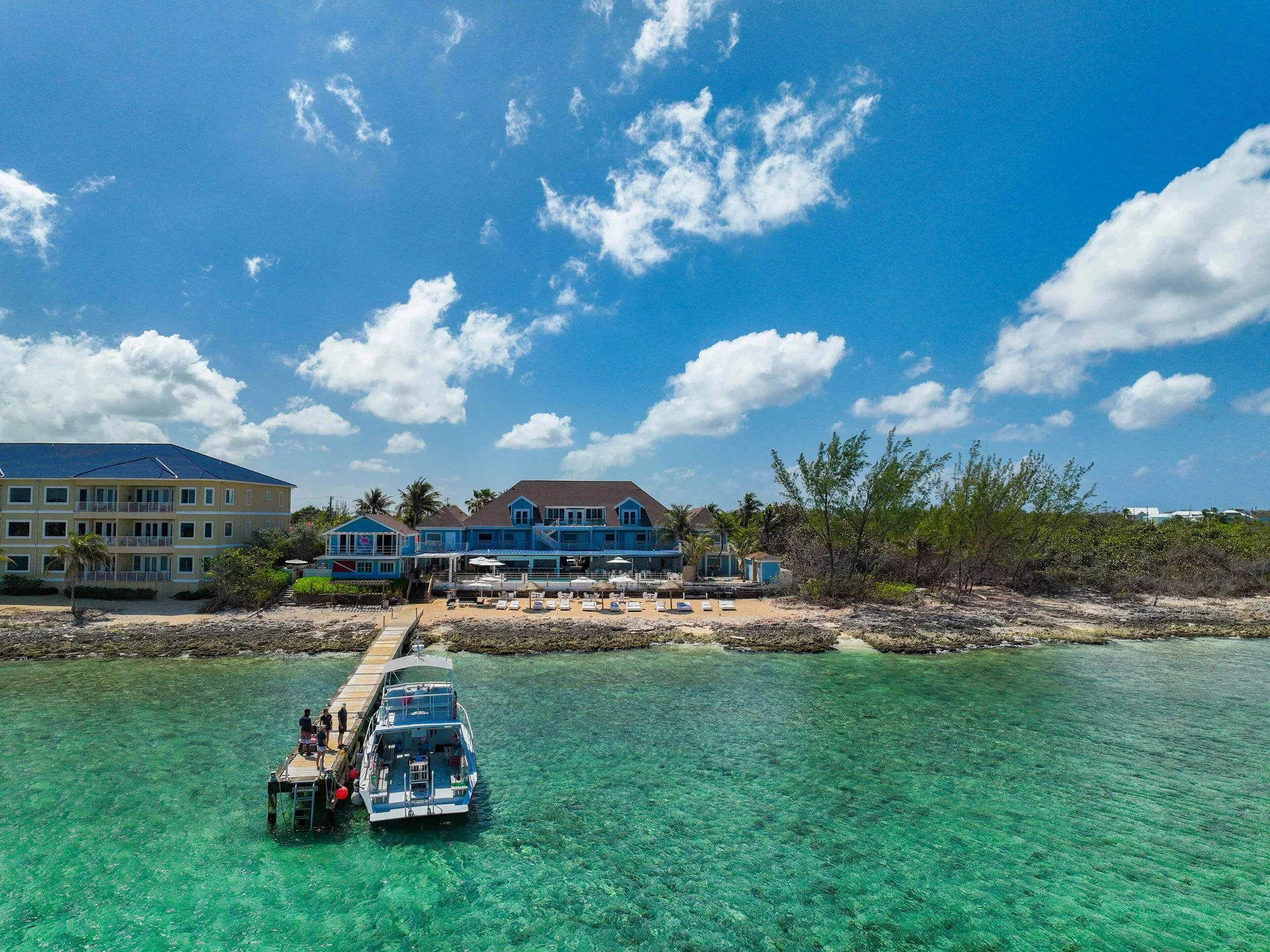 Pier, dive boat, beach, and waterfront buildings at Cobalt Coast Resort.