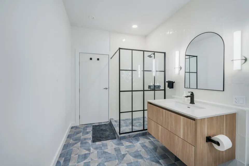Deluxe Room bathroom vanity, mirror, and glass shower at Cobalt Coast Resort.