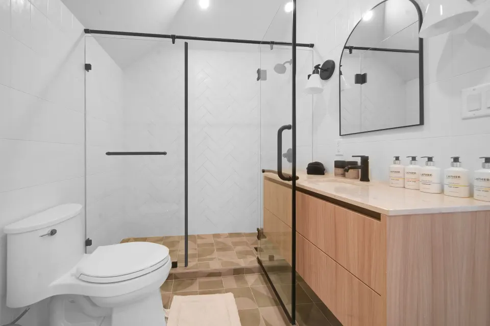 Corner Ocean View bathroom with glass shower, vanity, and toilet at Cobalt Coast Resort.
