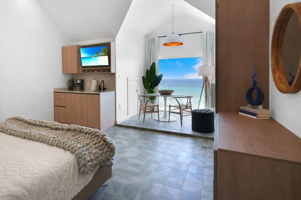 Corner Ocean View room with bed, dresser, mirror, and ocean-facing sitting area at Cobalt Coast Resort.