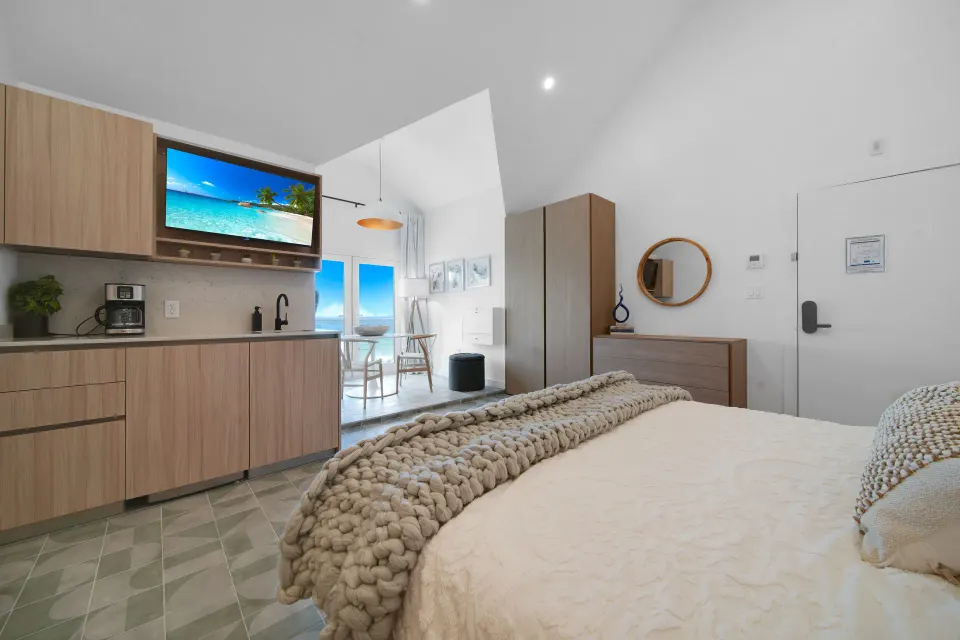 Corner Ocean View room with bed, kitchenette, TV, and entry door at Cobalt Coast Resort.