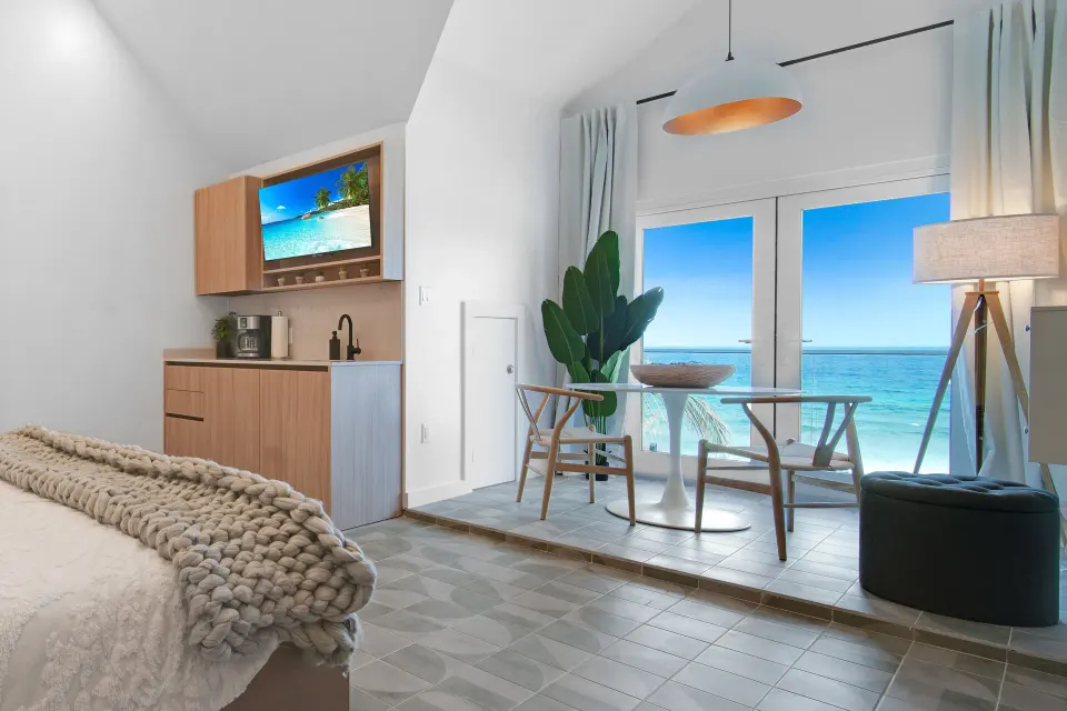 Corner Ocean View room sitting area by glass doors and kitchenette at Cobalt Coast Resort.