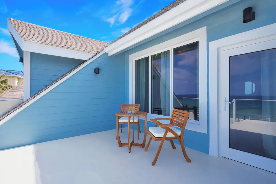 Ocean View room balcony with two chairs and a table at Cobalt Coast Resort.