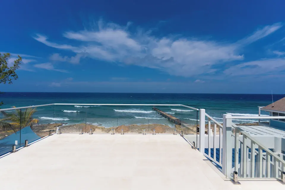Ocean View room terrace with glass railing and sea view at Cobalt Coast Resort.
