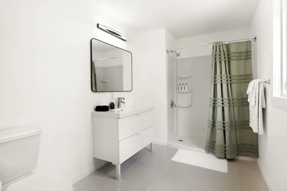Standard Room bathroom with white vanity, walk-in shower, and towel rail at Cobalt Coast Resort.