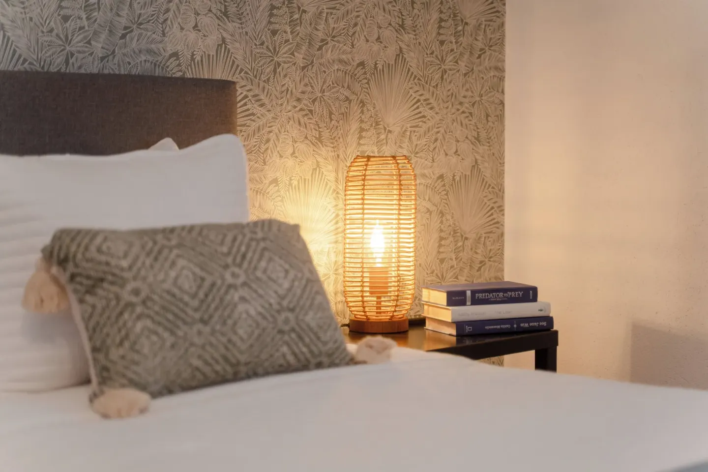 Standard Room bedside close-up with pillow, lamp and books at Cobalt Coast Resort.