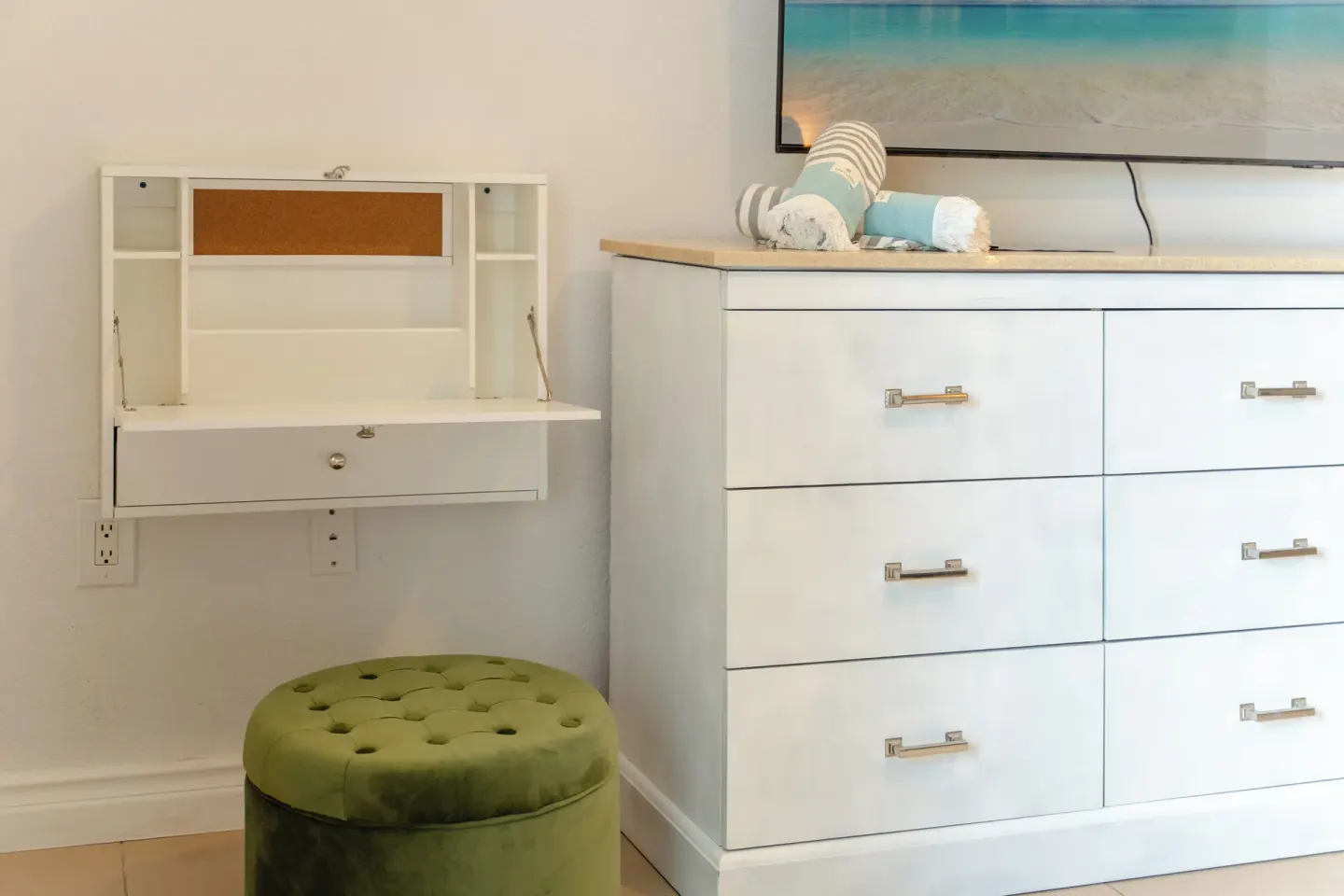 Standard Room storage with dresser, wall desk, TV and ottoman at Cobalt Coast Resort.