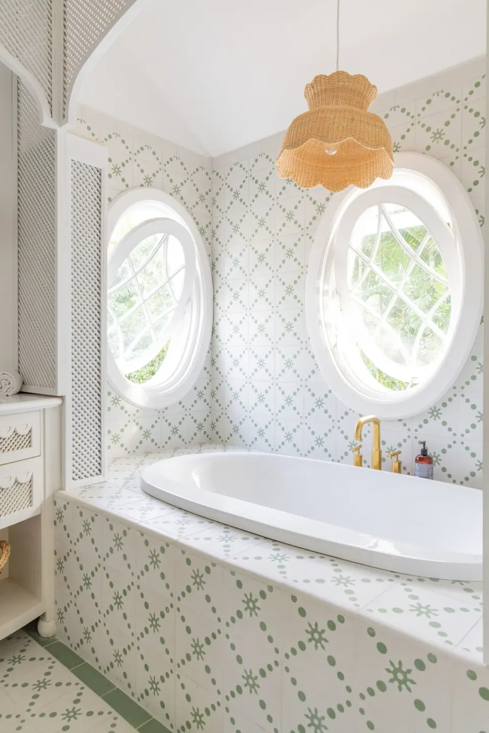 Tiled bathtub alcove with round windows and woven pendant at Cobblers Cove.