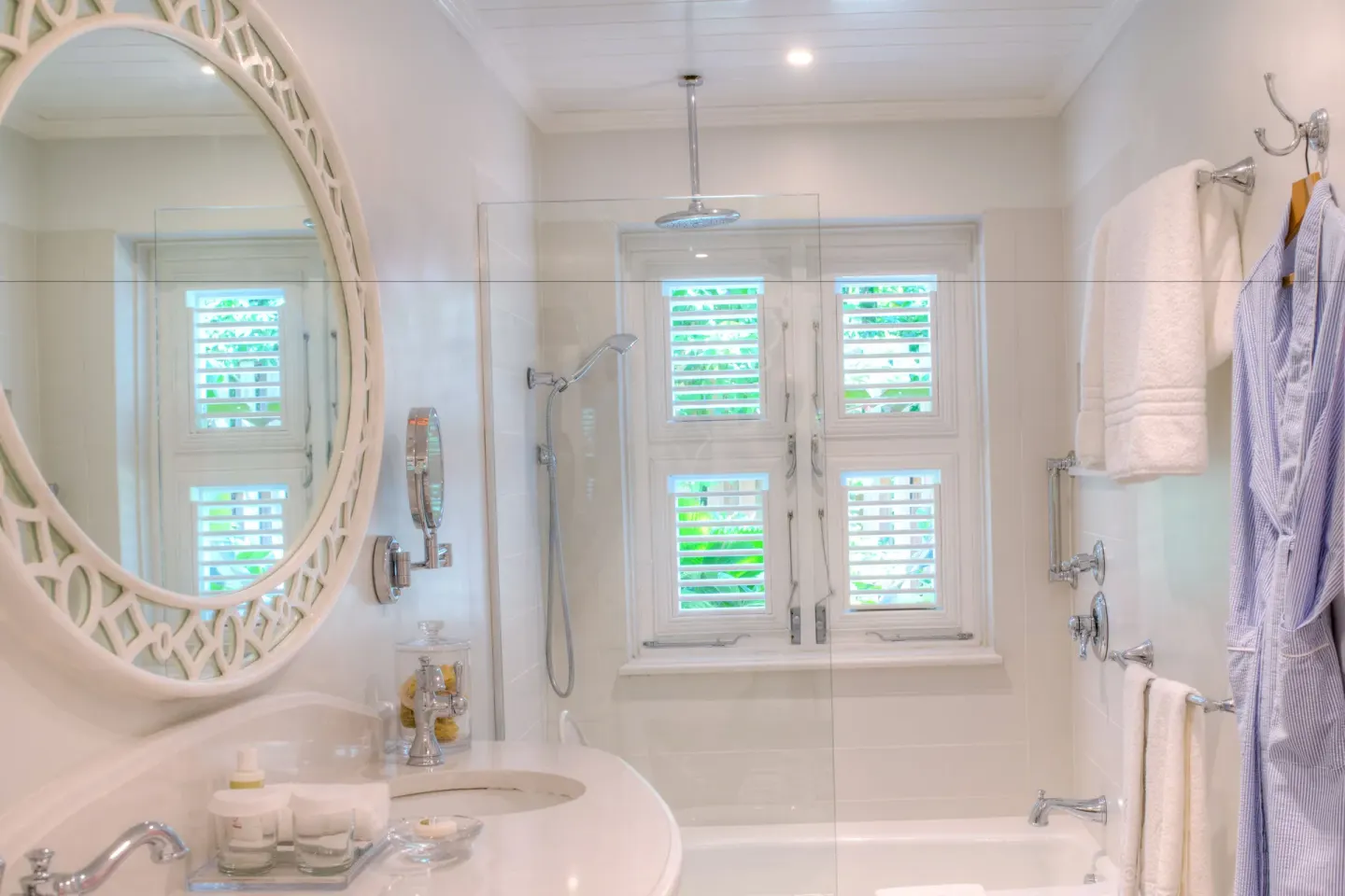 Bathroom vanity and glass shower with shutters and hanging robe at Cobblers Cove.