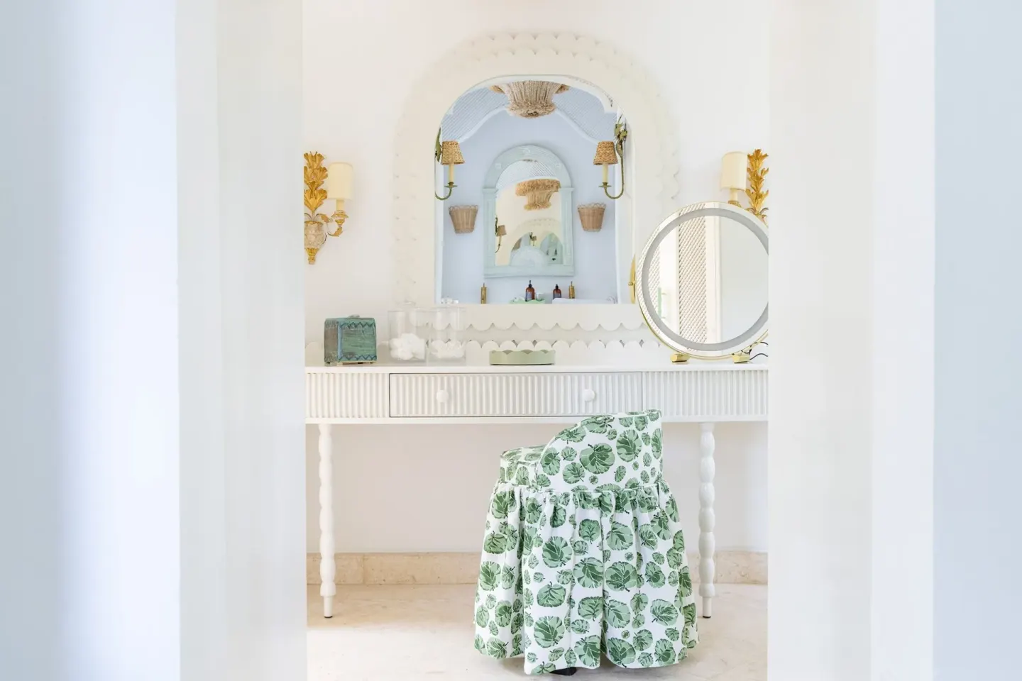 Dressing table with mirrors, wall sconces and floral chair at Cobblers Cove.