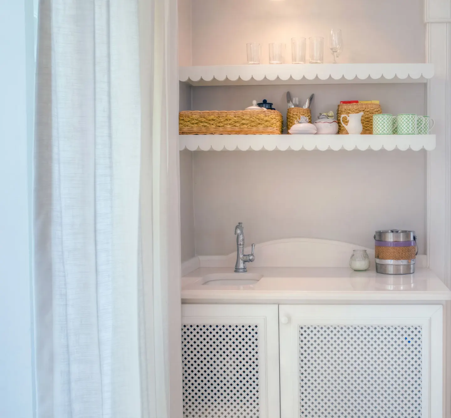 In-room refreshment nook with sink, shelves, glassware and mugs at Cobblers Cove.