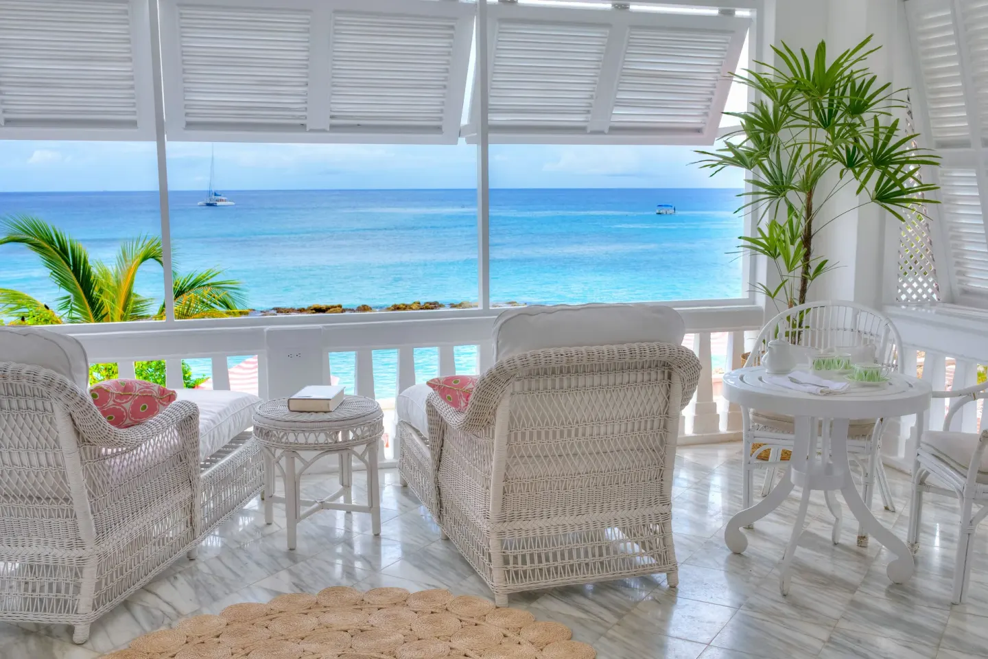 White wicker seating on an ocean-view balcony at Cobblers Cove.
