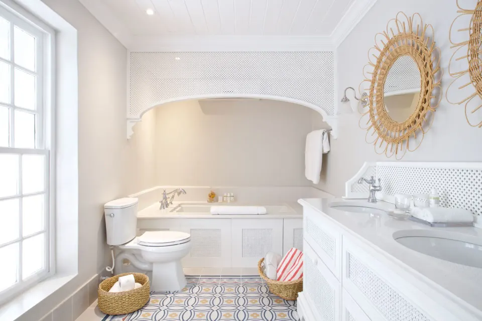 Camelot at the Great House bathroom at Cobblers Cove with bathtub, vanity and patterned tile floor.