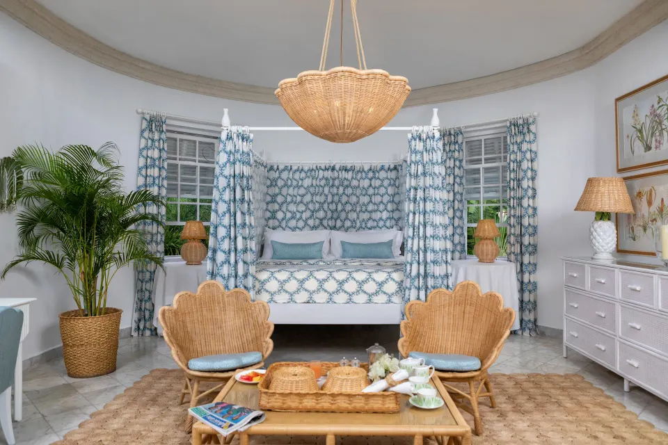 Camelot at the Great House at Cobblers Cove with king bed, wicker chairs and breakfast tray.