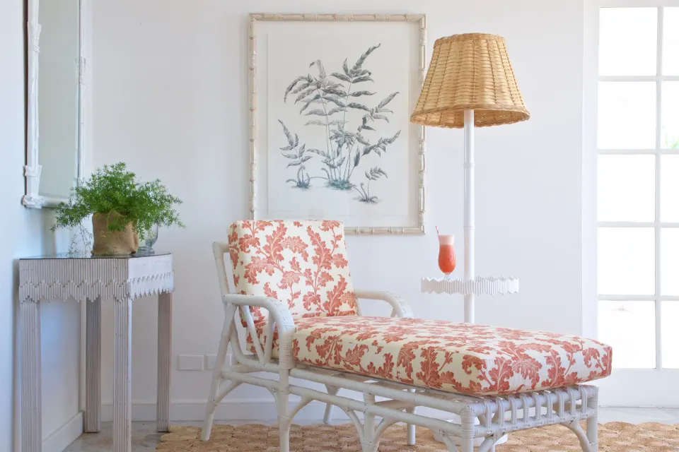 Colleton at the Great House sitting area with floral chaise and wicker lamp at Cobblers Cove.