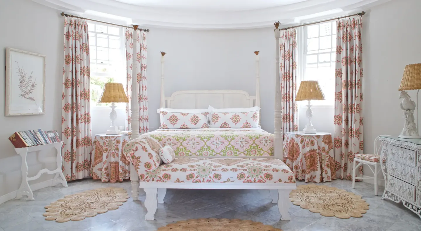 Colleton at the Great House bedroom with four-poster bed, chaise and wicker dresser at Cobblers Cove.