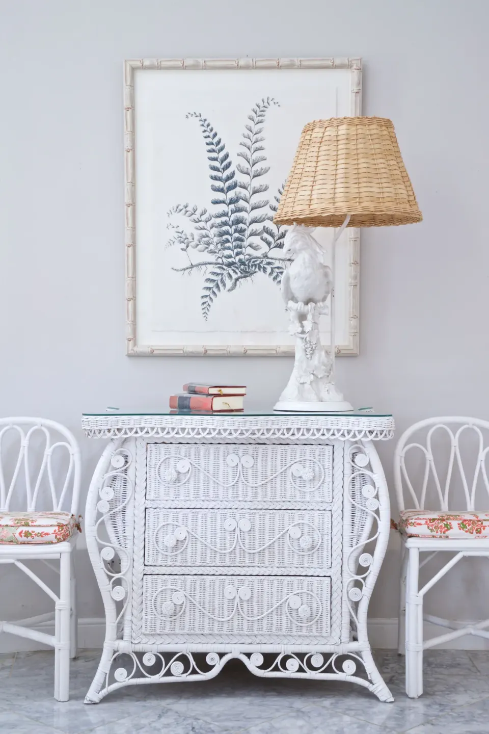 Colleton at the Great House white wicker dresser with chairs and botanical art at Cobblers Cove.