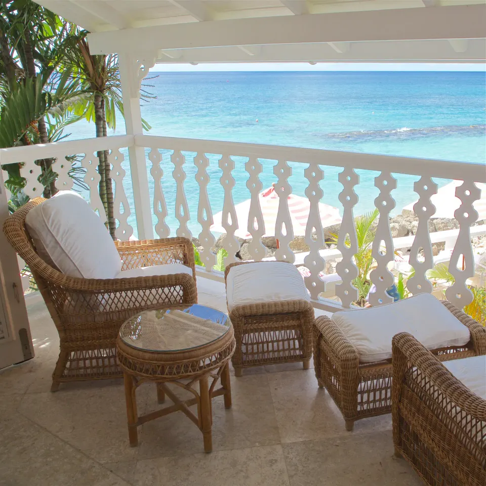 Ocean Front Suite balcony seating overlooking the beach and blue water at Cobblers Cove.