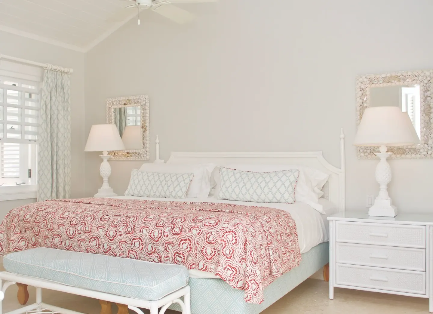 Ocean Front Suite bedroom with king bed and red patterned coverlet at Cobblers Cove.